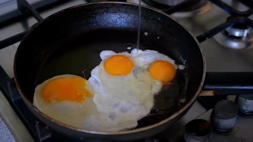 Tres huevos fritos fritos en una sartén. Cámara lenta