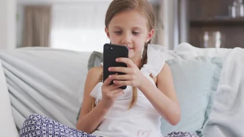 Young Girl Using Smartphone Sitting on Couch