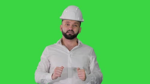 Engineer in a White Helmet Explaining Something To Camera on a Green Screen Chroma Key
