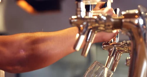 Brewer filling beer in beer glass from beer pump