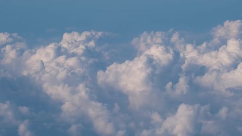 Aerial View From Airplane Window at High Altitude of Earth Covered with Puffy Cumulus Clouds Forming