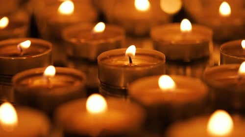 Many Small Burning Candles on a Black Background