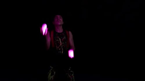Jongleur zeigt Tricks mit Lichtkugeln in der ganzen Dunkelheit