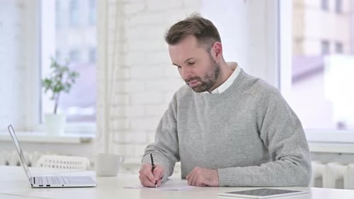 Adult Man Working and Writing at Desk