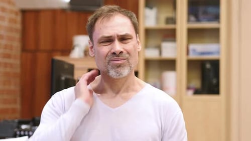 Man With Neck Pain Rubbing His Neck