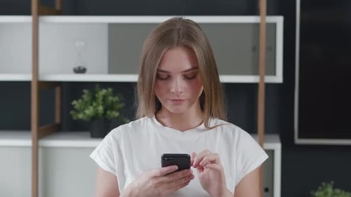 Smiling Young Student Woman Using Smartphone at Home Office, Happy Businesswoman Using Mobile Phone