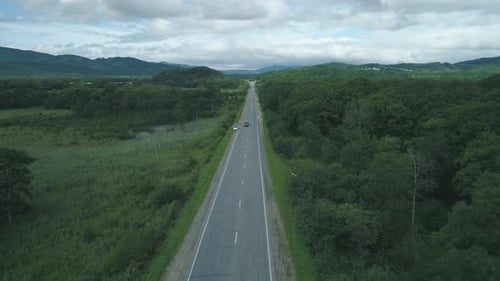 Aerial View Above Cars Driving Along Empty Countryside Road on Sunny Day