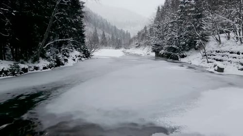 Aerial View Drone Moving Above the Frozen River in Mountains