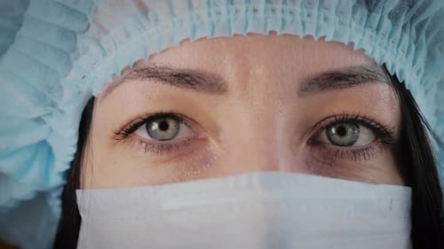 Close-up of healthcare worker wearing cap and mask