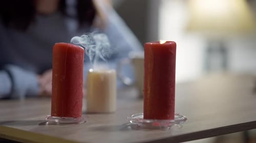Burning Candles with Woman Seated at Table