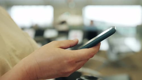 Woman Using Smartphone in Modern Office Environment