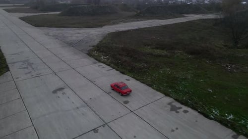 Red Car on Empty Concrete Road at Cloudy Autumn Day