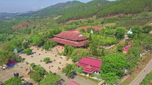 Drone Rotates Over Pagoda Territory Against Green Hills