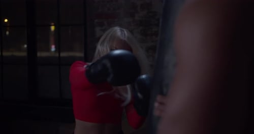 Boxing Coach Giving a Private Training To a Female Athlete Practicing a Punch in Urban Gym
