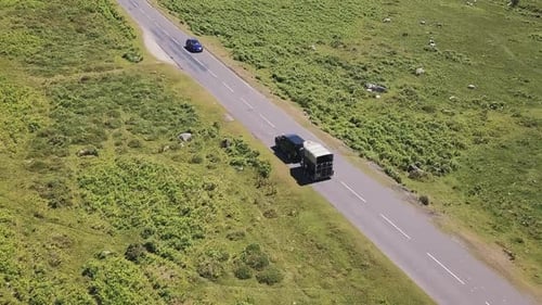 Horse trailer and two cars driving country road.