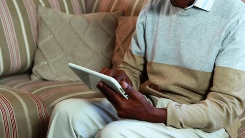 Senior Man Using Tablet Device on Couch