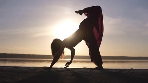 Woman Doing Yoga Pose on Beach at Sunset
