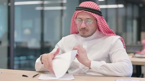 Man Writes and Crumples Paper in Modern Office