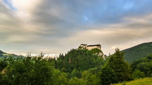 Clouds Over Historic Castle in Green Forest Landscape