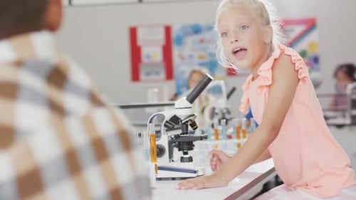 Video of happy caucasian girl with microscope during lesson