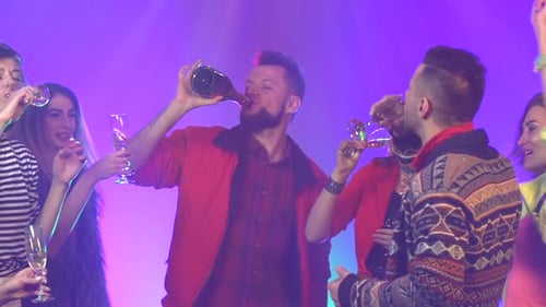 Amigos segurando champanhe curtindo festa. Fundo de fumaça. Câmera lenta