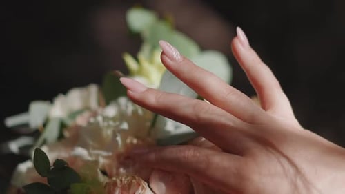 Woman's Hand Touches Elegant Wedding Bouquet