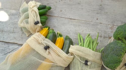 Verduras coloridas en bolsas reutilizables sobre un fondo de madera. Cero residuos. Reduzca los residuos plásticos