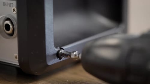 Drill Removes Screw From Electronic Device Casing