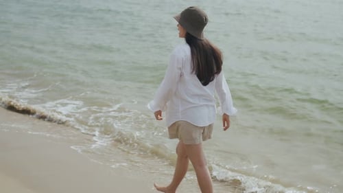 Asian beautiful caucasian female happiness walking on the beach on a holiday weekend.