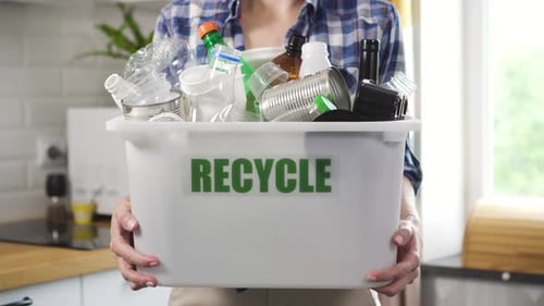 Young Adult Holding Recycle Bin Indoors