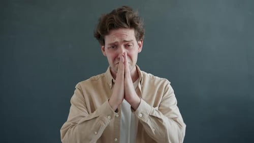 Anxious Man Clasping Hands Together