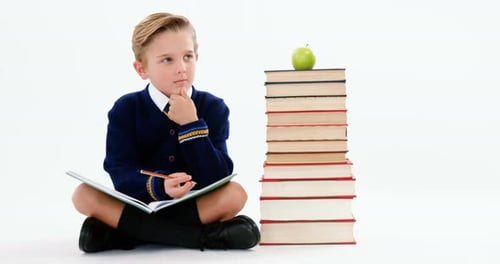 Thoughtful schoolboy doing her homework