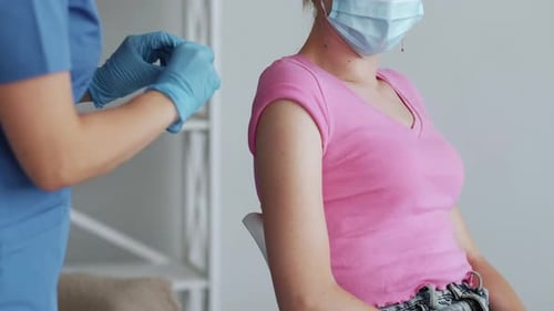 Medical Professional Applies Bandage After Vaccination