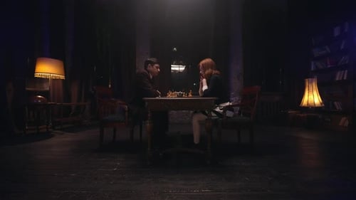 Two People Play Chess in Dimly Lit Room