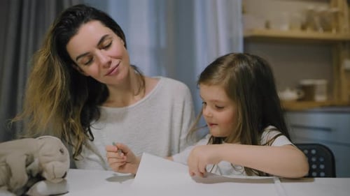 Mother and Child Drawing Together at Table Indoors