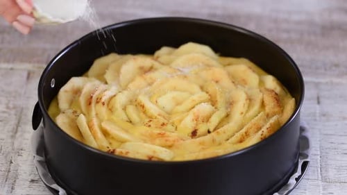 Sprinkling Sugar on Apple Pie in Baking Dish