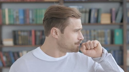 Fair Hair Man Coughing into Fist Indoors