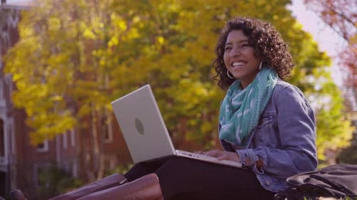College student on campus in fall using laptop computer