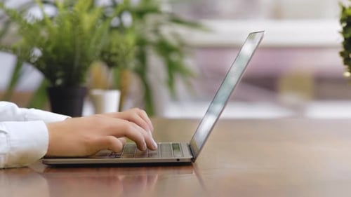 Hands Typing on Laptop Computer at Desk