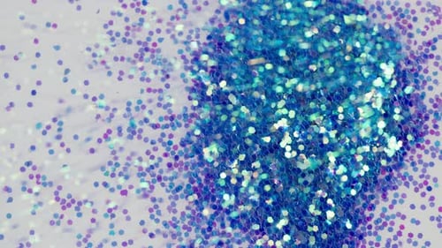 Blauer Glitzer auf weißem Hintergrund, glänzendes Puder, Nahaufnahme