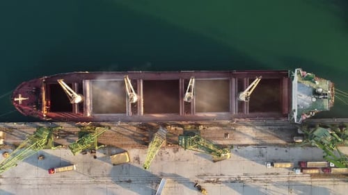 Aerial View of Big Cargo Ship Bulk Carrier is Loaded with Grain of Wheat in Port at Sunset
