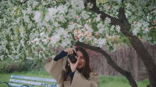 Woman Taking Photo with Camera in Blooming Park