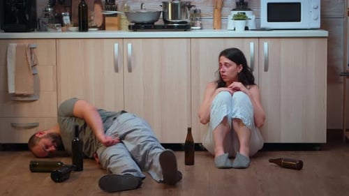 Woman with Bruises Sits Near Intoxicated Man