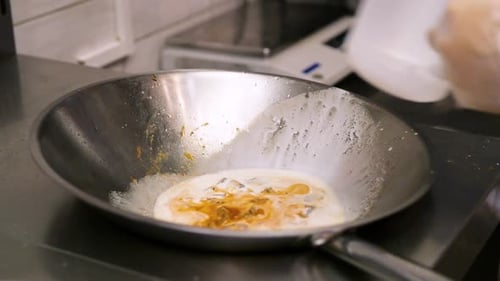 a Chef Prepares Fried Pieces of Meat Peppers in a Huge Wok in a Restaurant a Closeup View