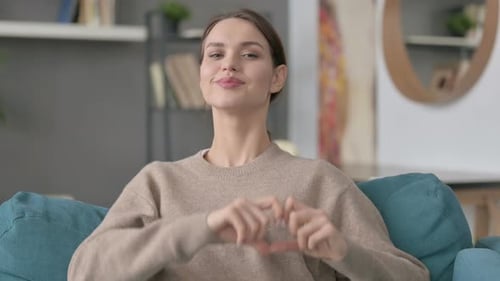 Smiling Woman Makes Heart Shape With Hands