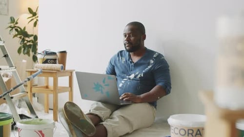 Man with Laptop Taking Break from Painting
