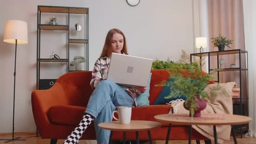 Woman Using Laptop Sitting on Couch