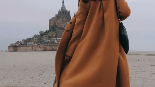 Close-up Fashionable Happy Tourist Woman Slowly Walking on Soft Sea Sand at Epic Mont Saint Michel