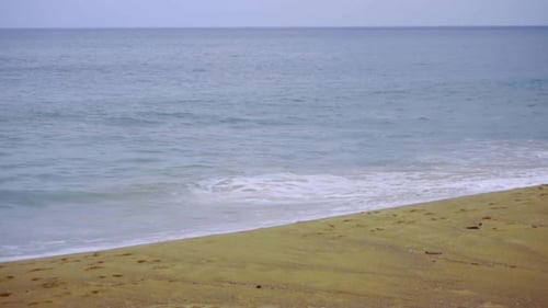 Waves Gently Rolling onto Sandy Beach Shore