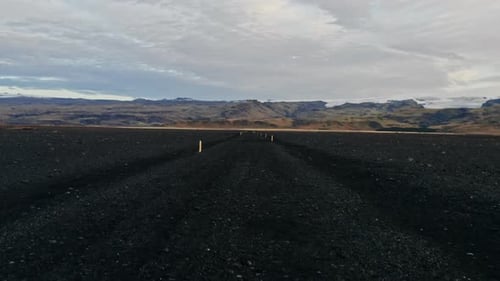 Black Rocky Landscape Under Cloudy Sky Aerial View